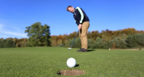 A golfer on a putting green playing golf.